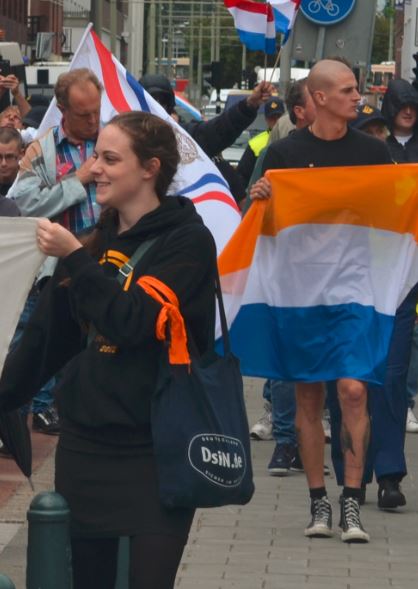 Gertrud Bossdorf van Identitair Verzet. Achter haar een man met prinsenvlag